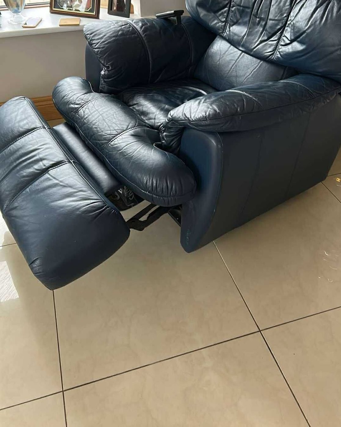 A black recliner with the footrest extended, before
