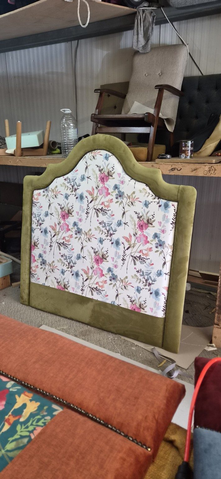 Floral upholstered headboard standing in the workshop